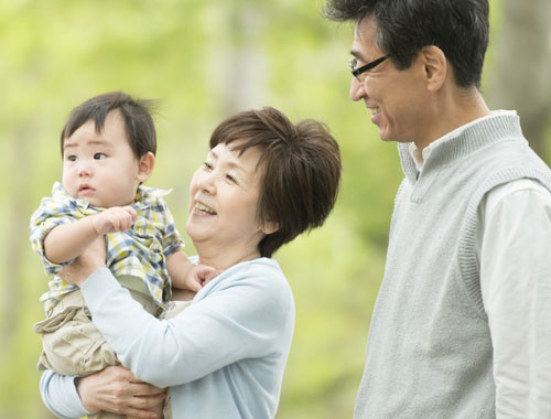 Grandparents holding baby while on an outdoor walk