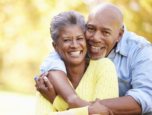 Smiling middle aged couple pose for portrait outdoors